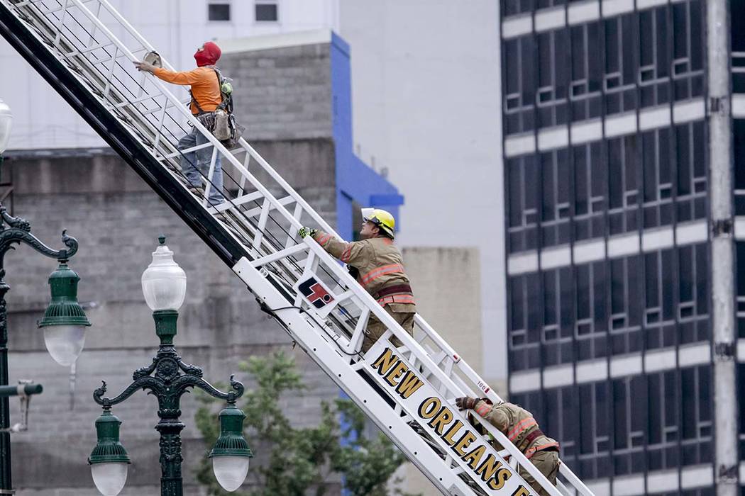 A rescued worker, left, and a firefighter look back at the damaged building after a large porti ...
