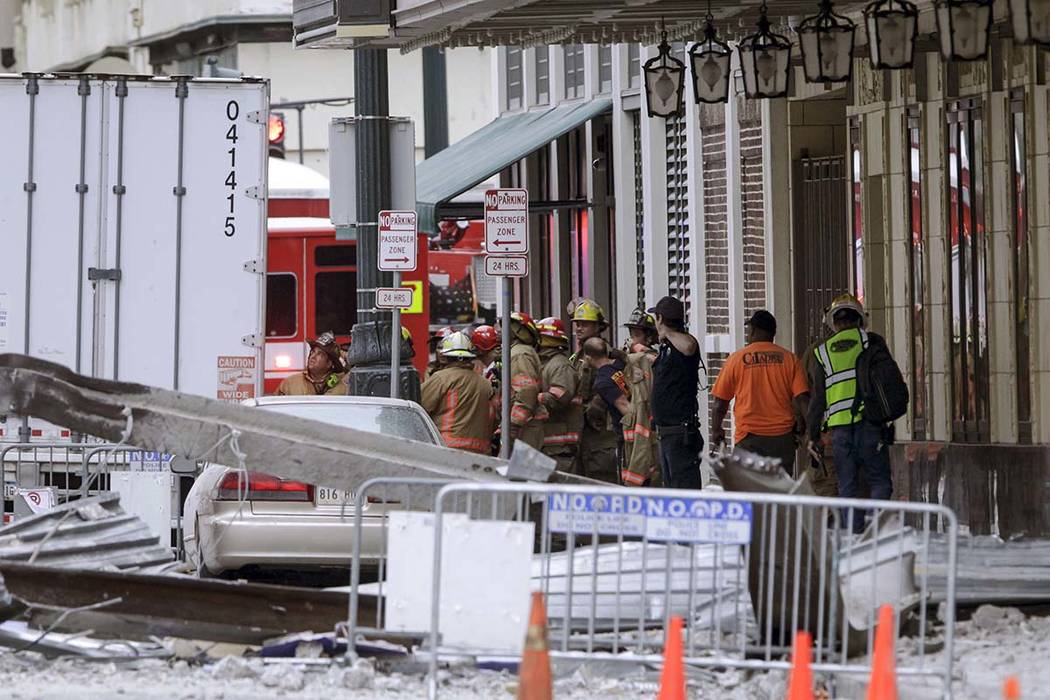 Construction workers are helped by emergency personnel after a large portion of a hotel under c ...