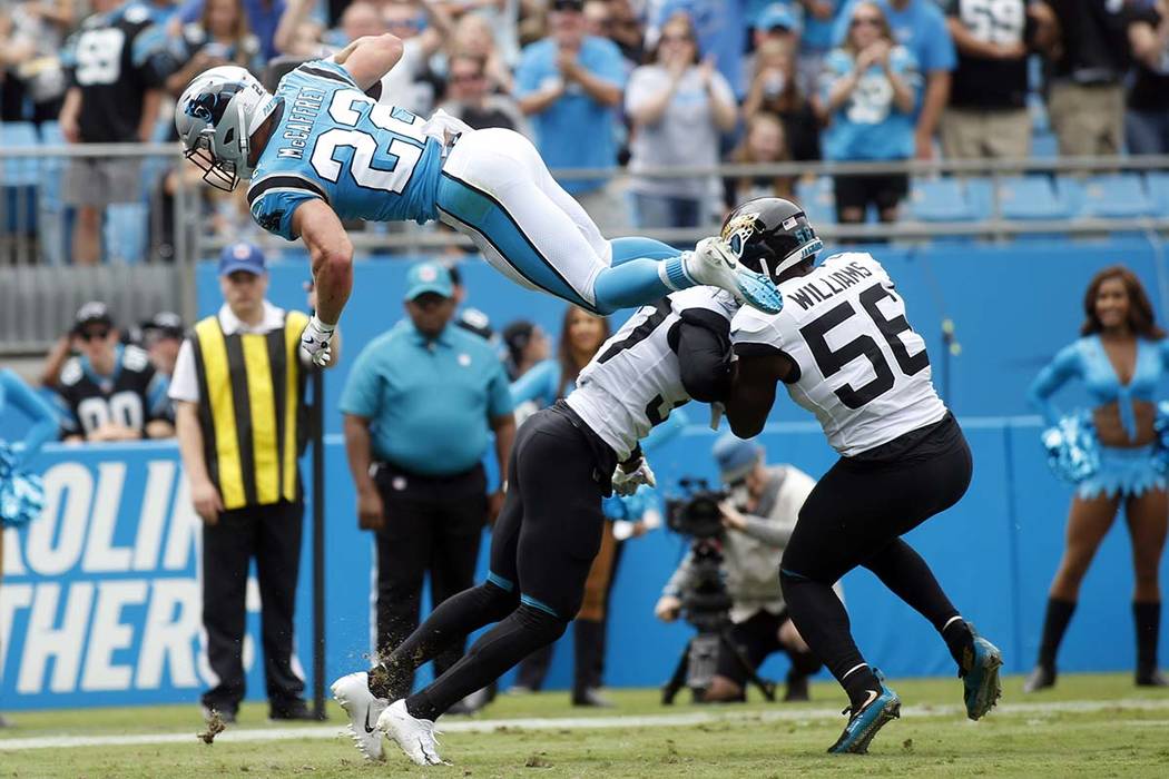 Carolina Panthers running back Christian McCaffrey (22) jumps over Jacksonville Jaguars cornerb ...