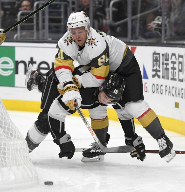 Vegas Golden Knights center Jonathan Marchessault, top, smothers Los Angeles Kings defenseman B ...