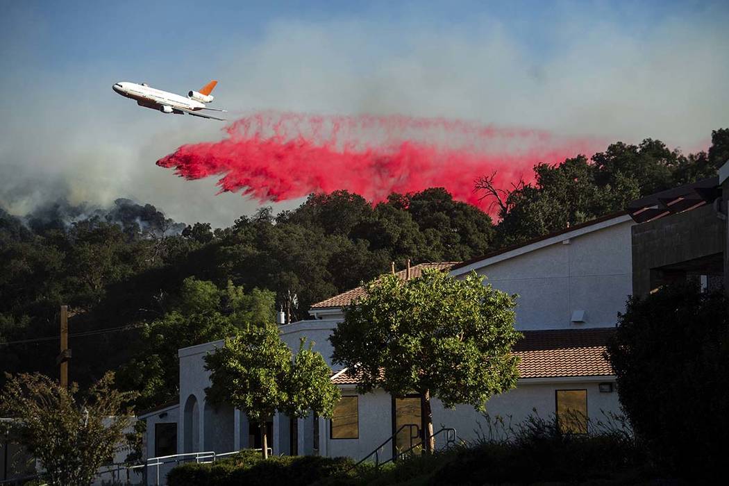 An air tanker drops retardant behind the Newhall Church of the Nazarene while battling the Sadd ...