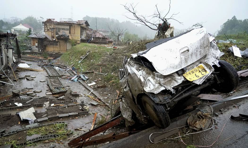 A damaged car lies on the ground following a strong wind in Ichihara, Chiba, near Tokyo Saturda ...