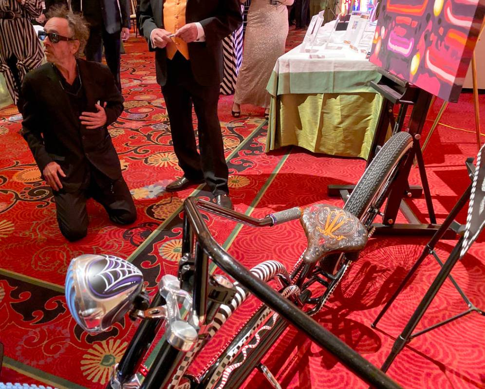 Tim Burton signs a custom bicycle by Brad Marlon up for auction during cocktail hour at The Neo ...