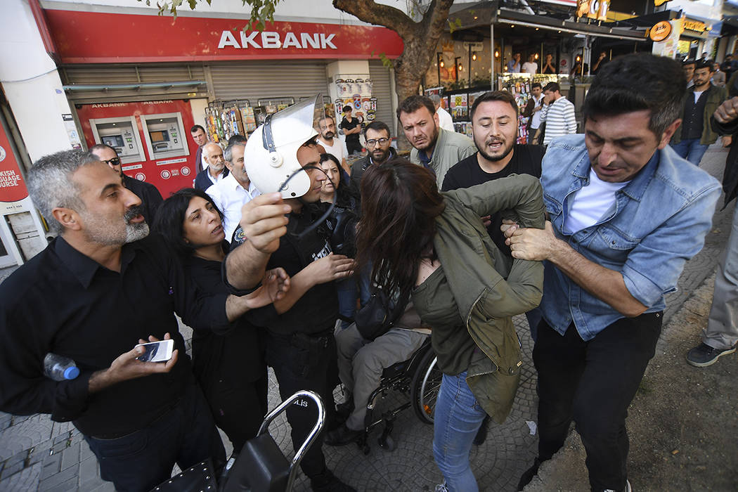 Security officials detain a pro-Kurdish party member who is protesting against Turkey's militar ...