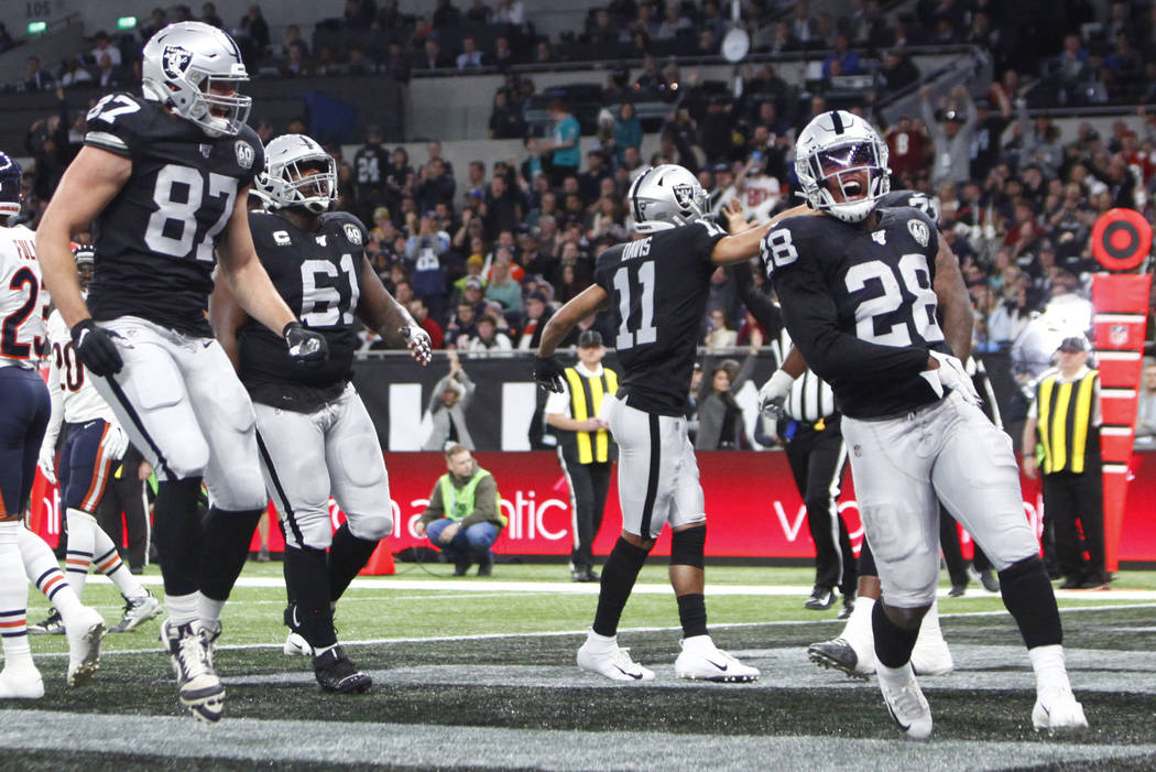 Oakland Raiders tight end Foster Moreau (87) and Oakland Raiders center Rodney Hudson (61) run ...