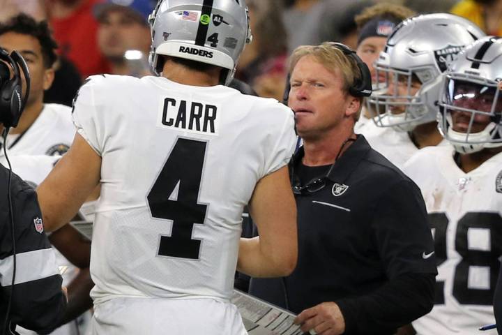 Oakland Raiders quarterback Derek Carr (4) speaks to head coach Jon Gruden on the sideline duri ...