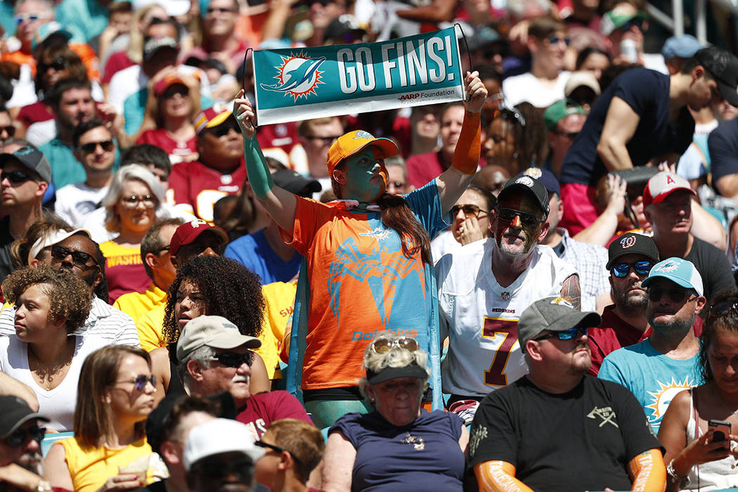 Miami Dolphins fans cheer the team, during the first half at an NFL football game against the W ...