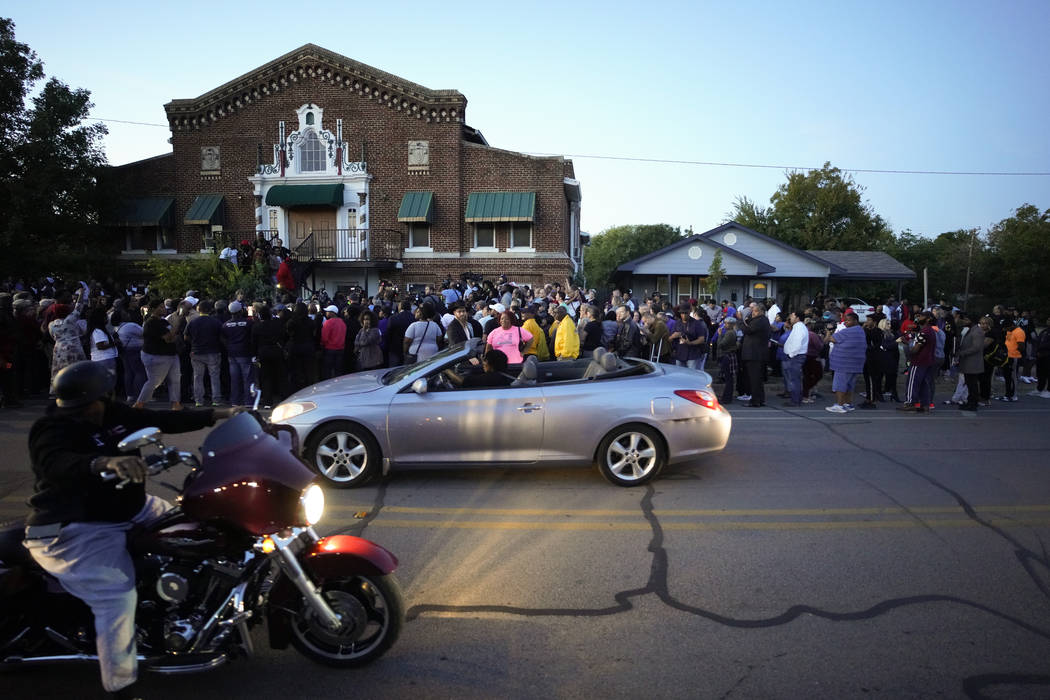 A large crowd of protesters gather outside the house, right, where Atatiana Jefferson was shot ...