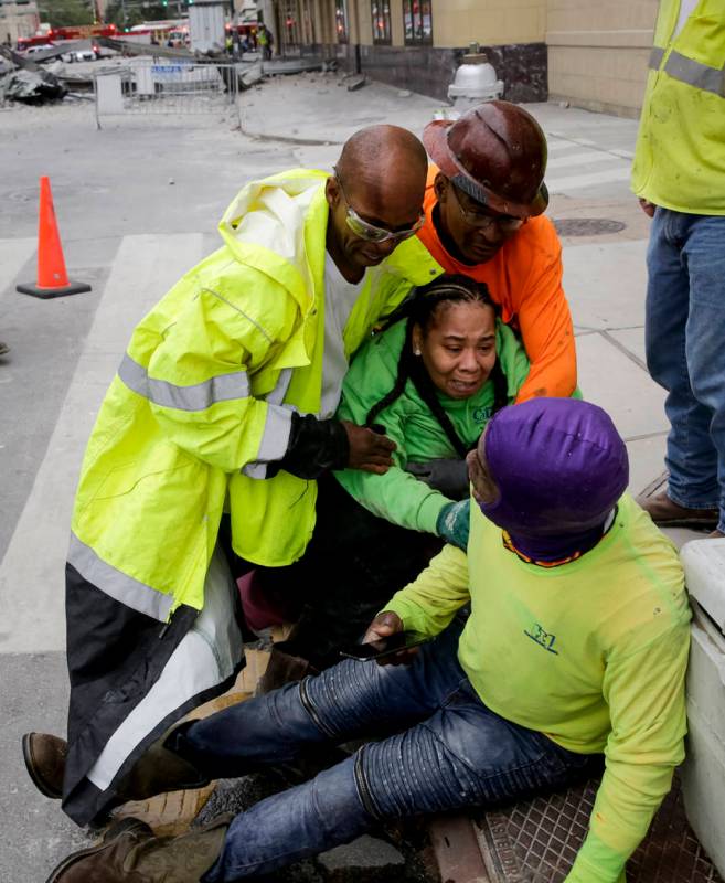 Workers are helped after a large portion of a hotel under construction suddenly collapsed in Ne ...