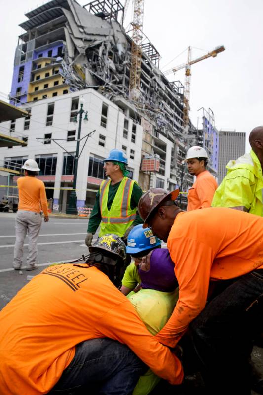 Workers are helped after a large portion of a hotel under construction suddenly collapsed in Ne ...