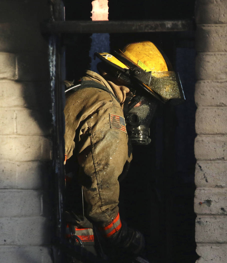 A Clark County firefighter battles a fire in a commercial area at 824 E. Sahara Ave., on Monday ...