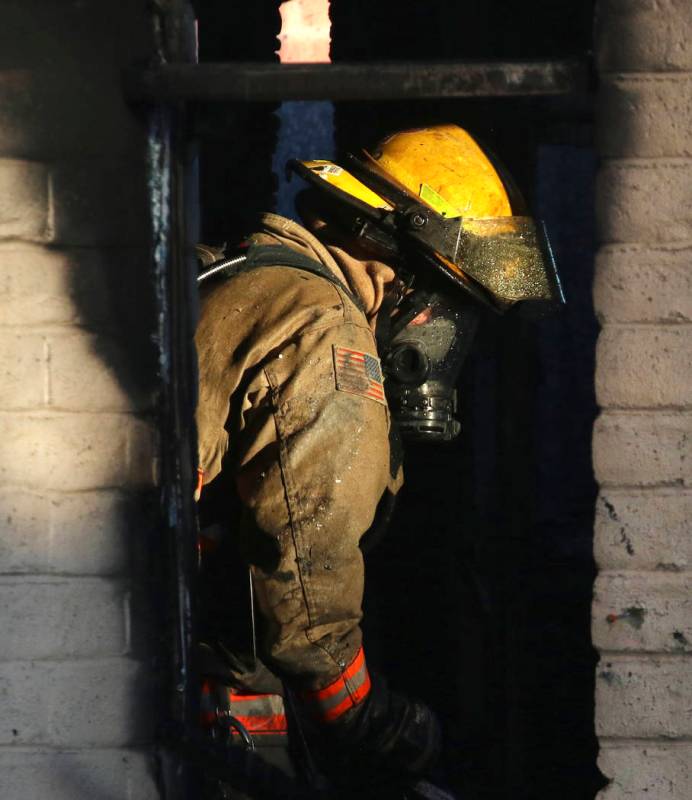 A Clark County firefighter battles a fire in a commercial area at 824 E. Sahara Ave., on Monday ...