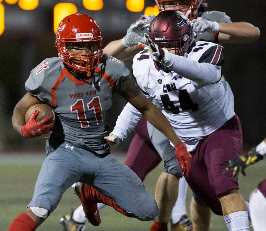 Arbor View senior running back Jaedyn Jackson (11) cuts up field past Faith Lutheran junior def ...