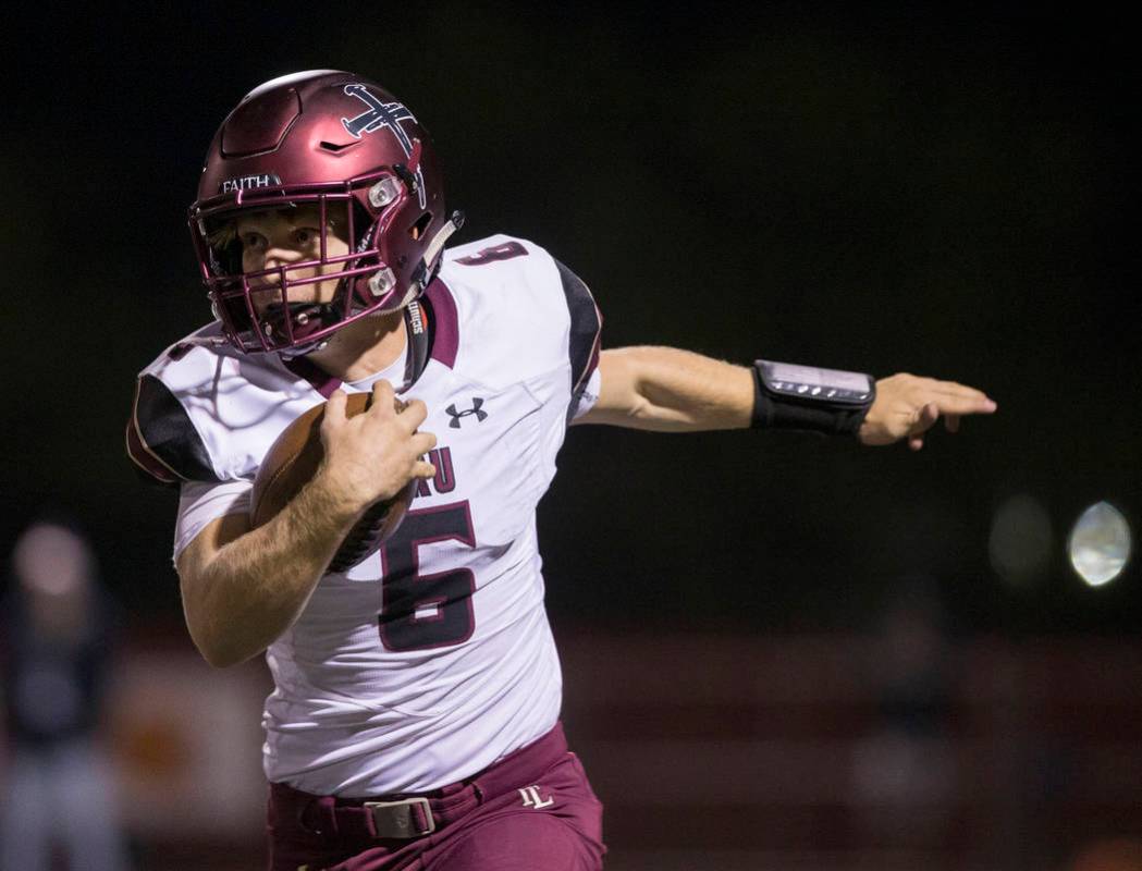 Faith Lutheran junior quarterback Grant Wood (6) scrambles down the sideline during the first q ...