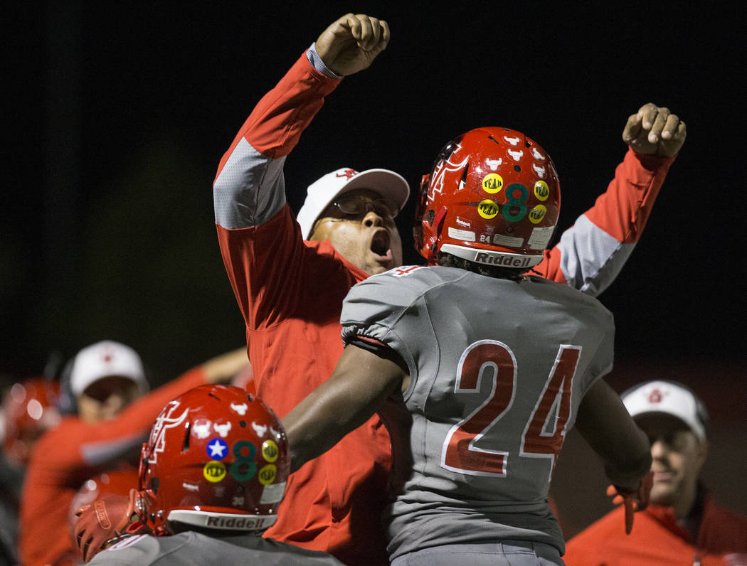 Arbor View senior running back Daniel Mitchell (24) celebrates with defensive line coach Corey ...