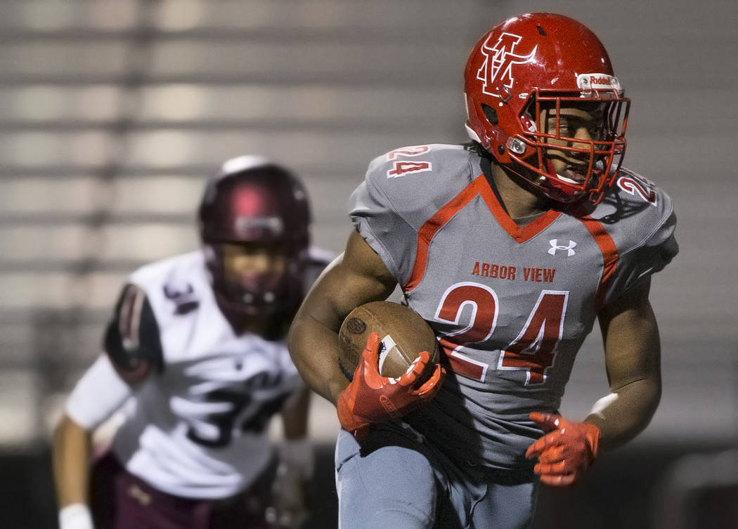 Arbor View senior running back Daniel Mitchell (24) cuts up field past Faith Lutheran sophomore ...