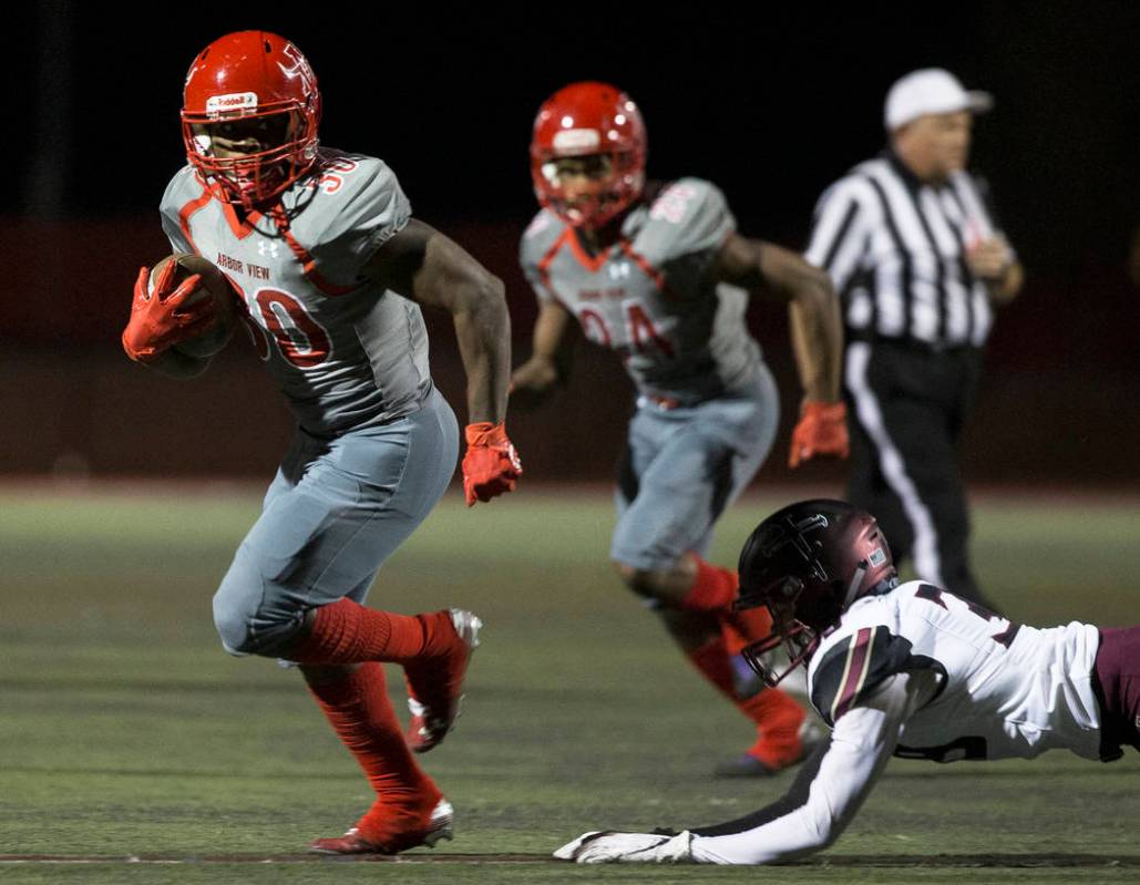 Arbor View senior running back Darius Williams (30) breaks down the sideline past Faith Luthera ...