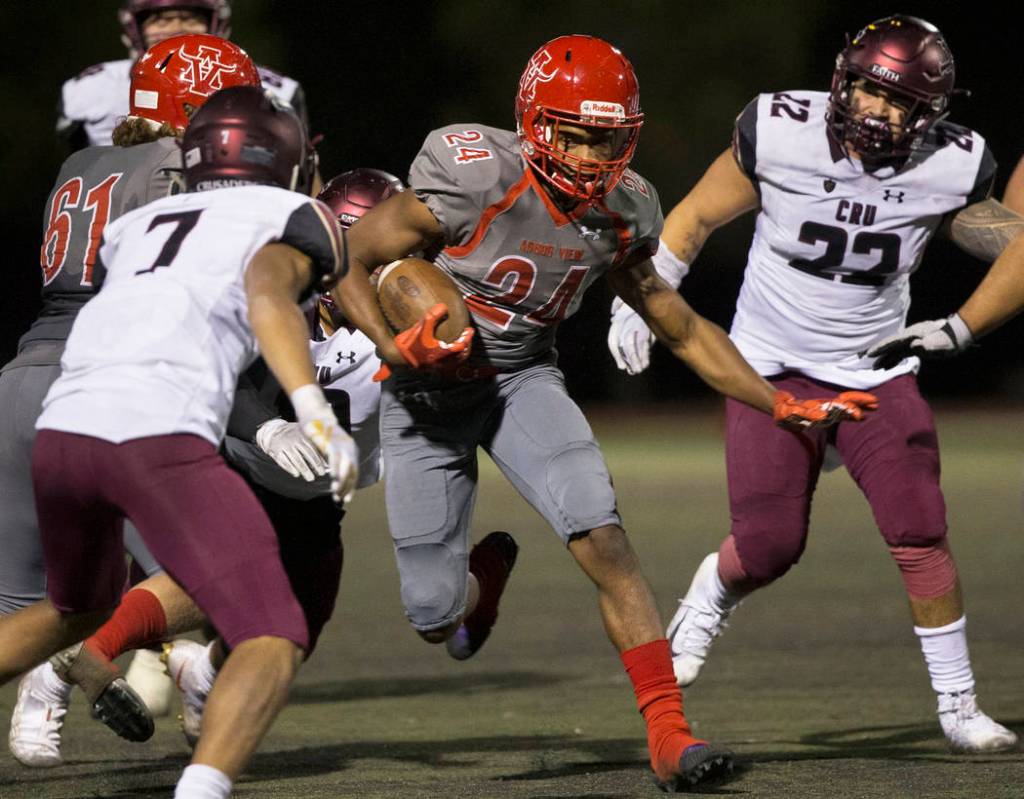 Arbor View senior running back Daniel Mitchell (24) cuts up field past Faith Lutheran senior li ...