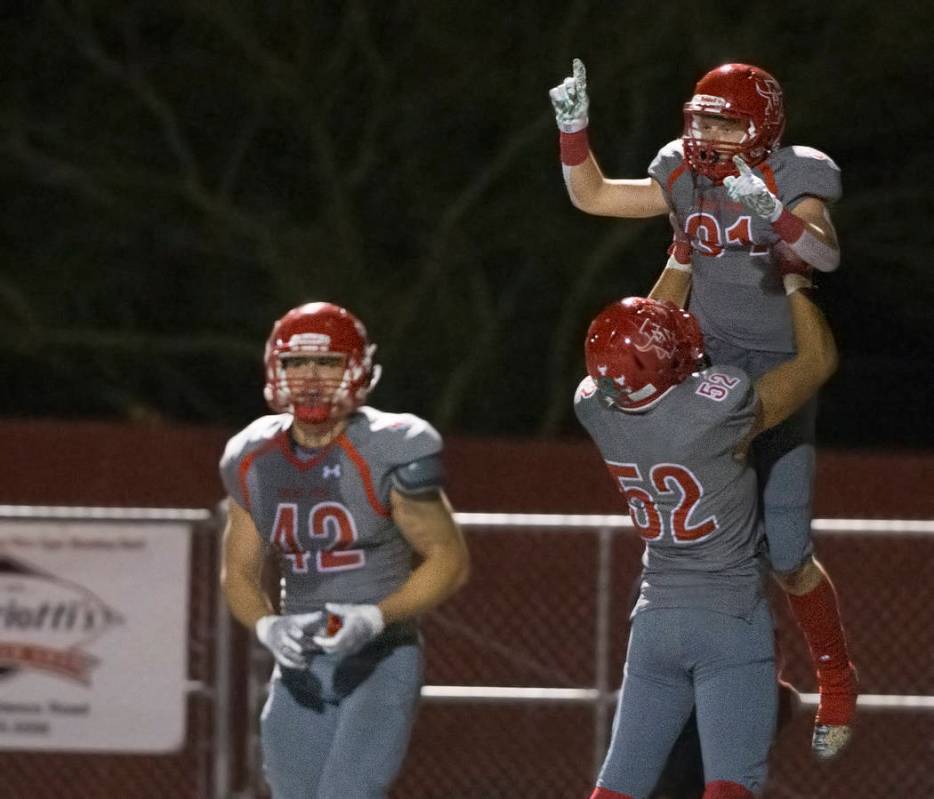 Arbor View senior running back Justin Hausner (31) celebrates with teammate Hunter Litchford (5 ...