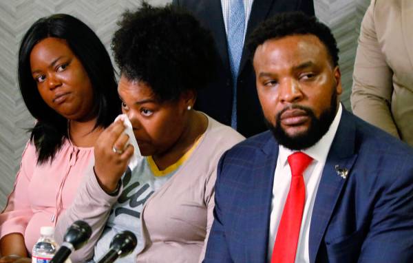 Amber Carr, center, wipes a tear as her sister, Ashley Carr, left, and attorney Lee Merritt, ri ...