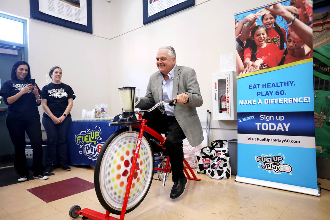 Gov. Steve Sisolak peddles a bike that powers a blender to make a smoothie at Staton Elementary ...