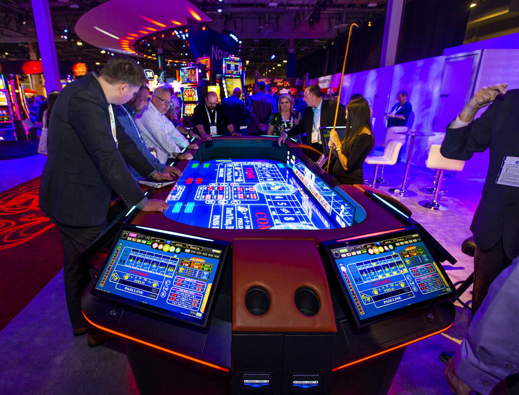 Attendees play on a new digital craps table from Aruze Gaming during the Global Gaming Expo 201 ...
