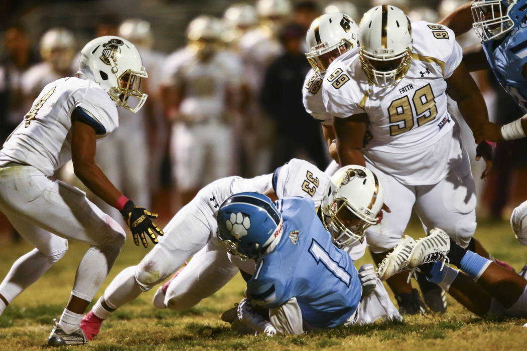 Faith Lutheran's Leonardo Mendoza (33) stops Centennial's Jordan Smith (1) during the second ha ...