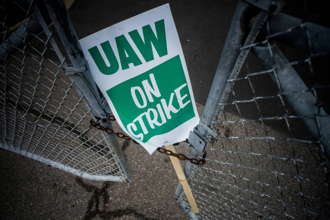 A Sept. 16, 2019, file photo, shows a United Auto Workers strike sign resting between the chain ...
