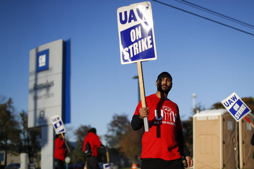 An Oct. 9, 2019, file photo a member of the United Auto Workers walks the picket line at the Ge ...