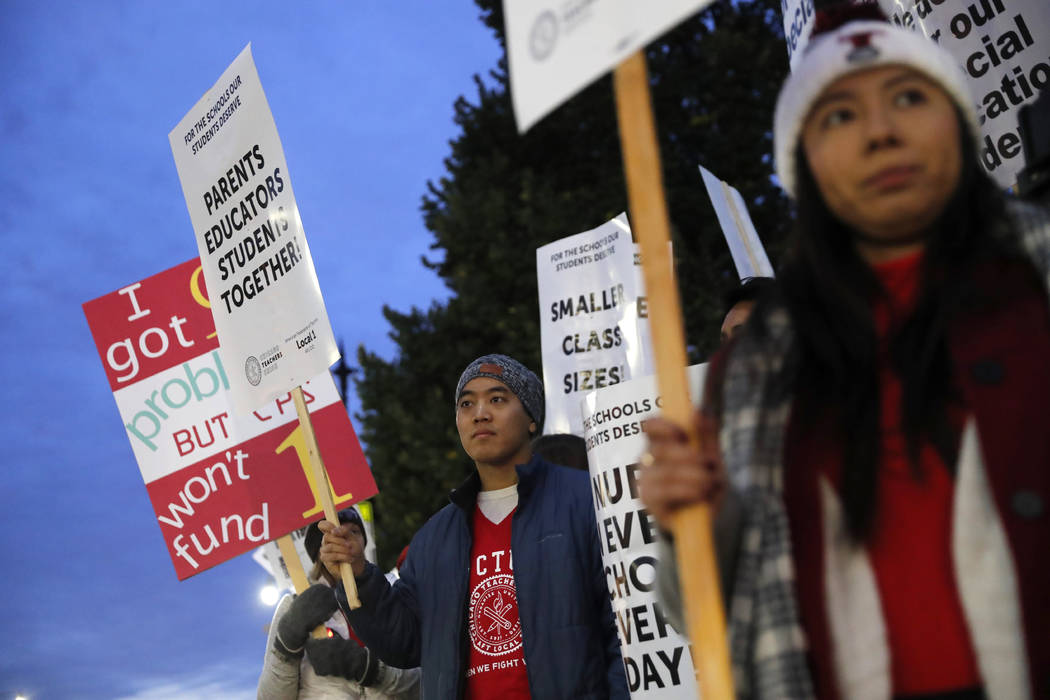 Striking teachers and supporters walk a picket line outside Lane Tech High School, in Chicago, ...