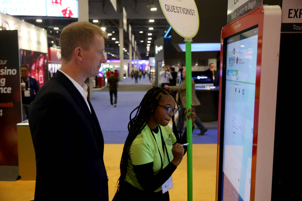 Dajiana Weeks of Las Vegas helps John Hagan of London at 2019 Global Gaming Expo at the Sands E ...