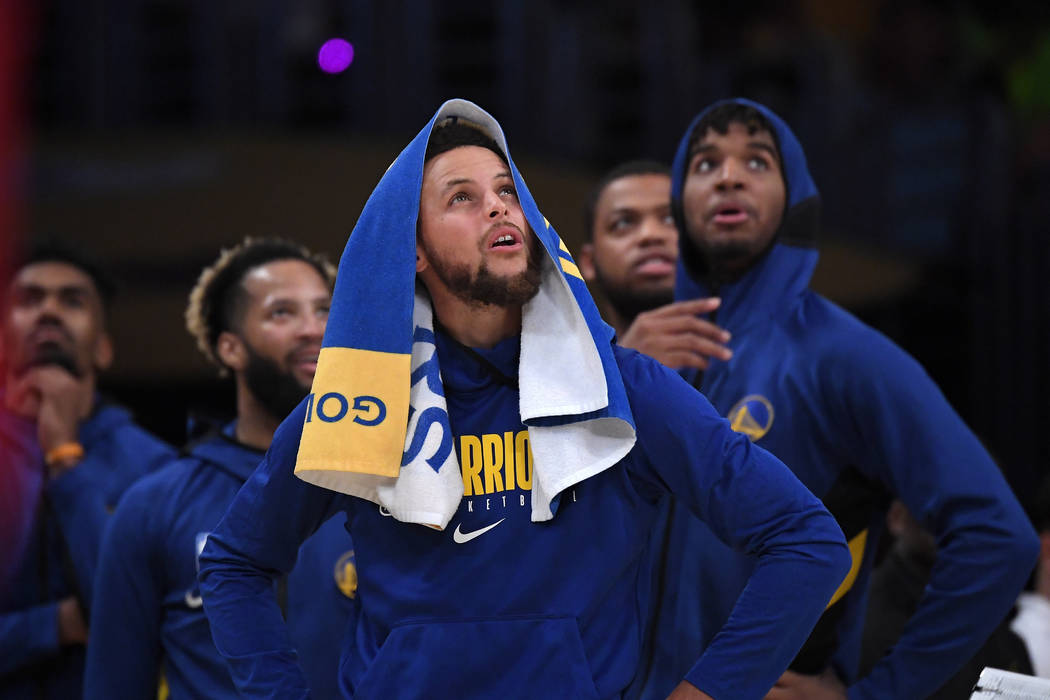 Golden State Warriors guard Stephen Curry looks at a replay along with teammates during the sec ...