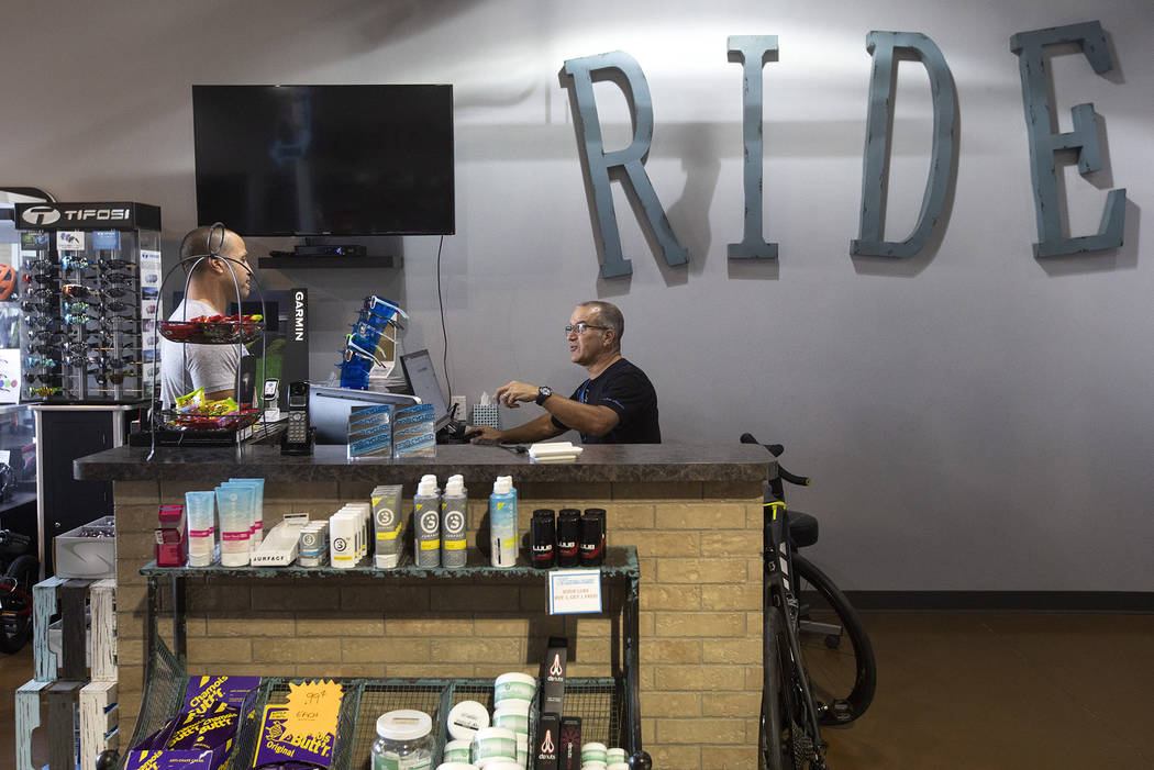 Joe Vara of Las Vegas purchases a repair on his bicycle from Pro Cyclery employee Shane Broussa ...