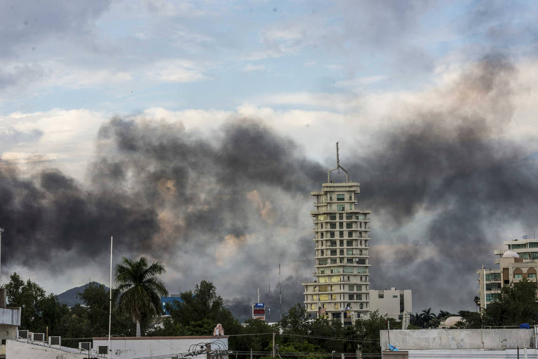 Smoke from burning cars rises due in Culiacan, Mexico, Thursday, Oct. 17, 2019. An intense gunf ...