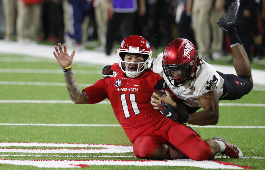 UNLV defensive back Evan Austrie tackles Fresno State quarterback Jorge Reyna during the first ...