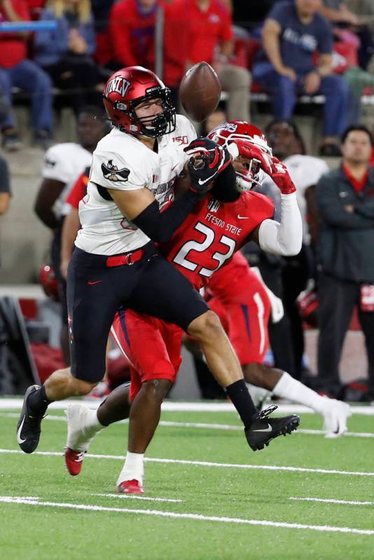 UNLV wide receiver Jacob Gasser, left, tries to haul in a pass that was eventually intercepted, ...