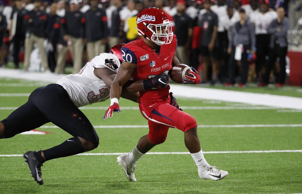 UNLV linebacker Jacoby Windmon tries to tackle Fresno State running back Ronnie Rivers, who sco ...