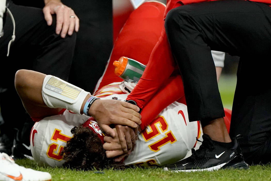 Kansas City Chiefs quarterback Patrick Mahomes (15) is helped by trainers after getting injured ...