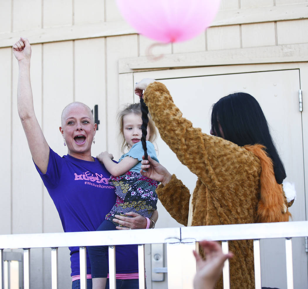 Jessica Hopson, left, holding her daughter, Willow, 3, reacts after the hair of Ronnow Elementa ...