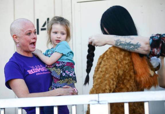 Jessica Hopson, left, holding her daughter, Willow, 3, reacts after the hair of Ronnow Elementa ...