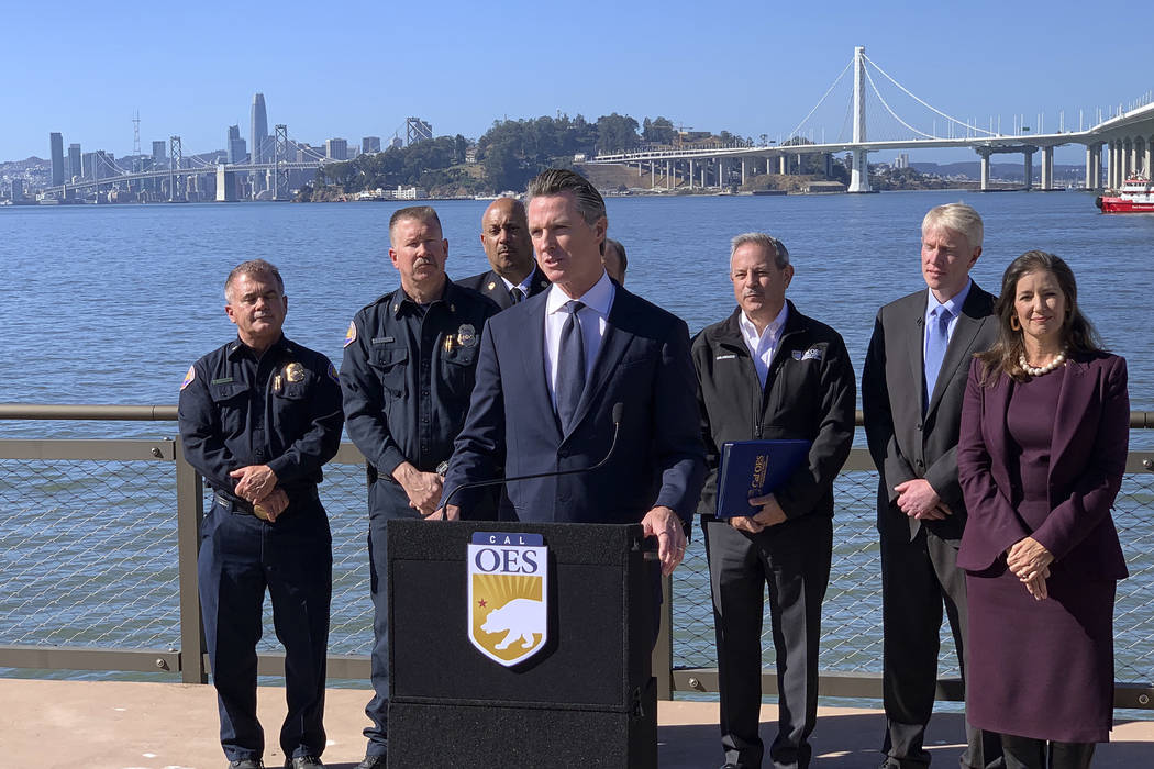 Gov. Gavin Newsom, center, speaks at a news conference with other officials to announce the sta ...