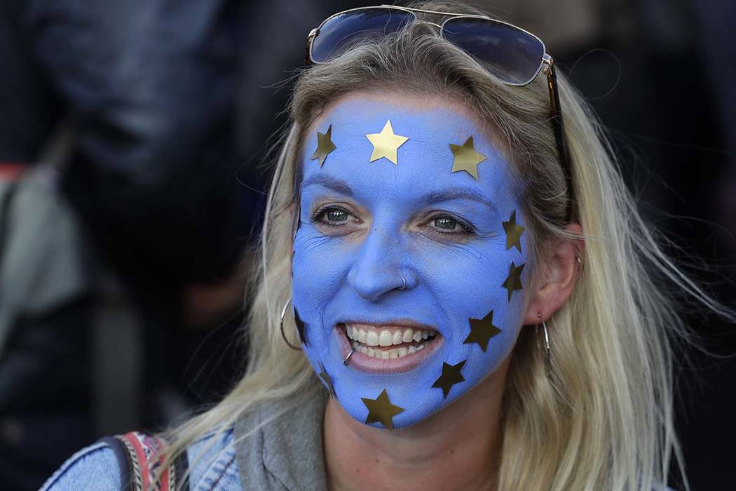 A woman has the EU flag painted on her face as she and other anti-Brexit protestors march in Lo ...