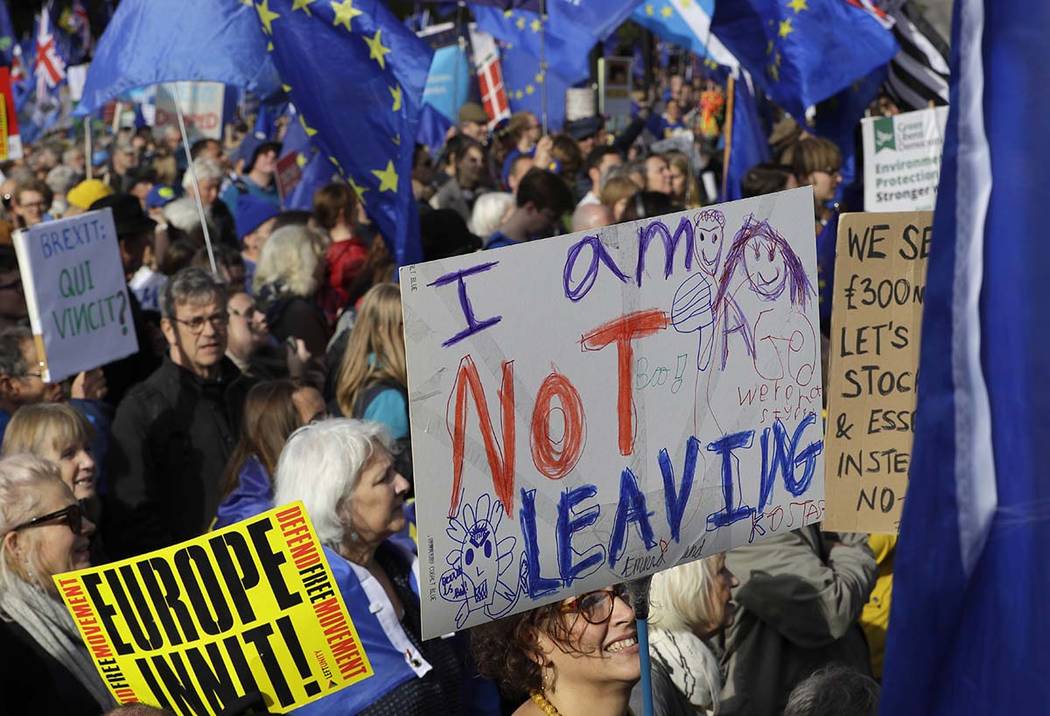 Anti-Brexit supporters carry signs and EU flags during a march in London, Saturday, Oct. 19, 20 ...