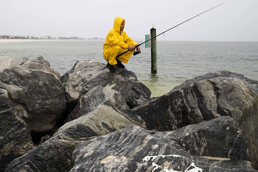 Michael Foster fishes as Tropical Storm Nestor approaches, Friday, Oct. 18, 2019 in Mexico Beac ...