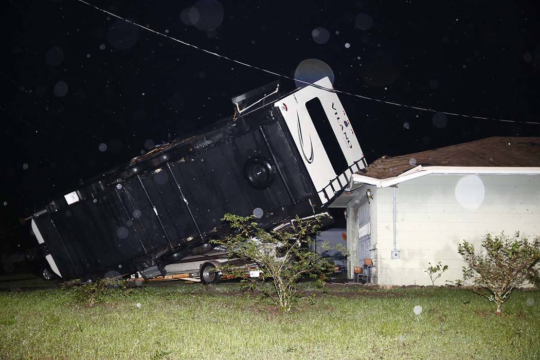 A camper rests on top of a boat trailer and the corner of a home as Tropical Storm Nestor passe ...