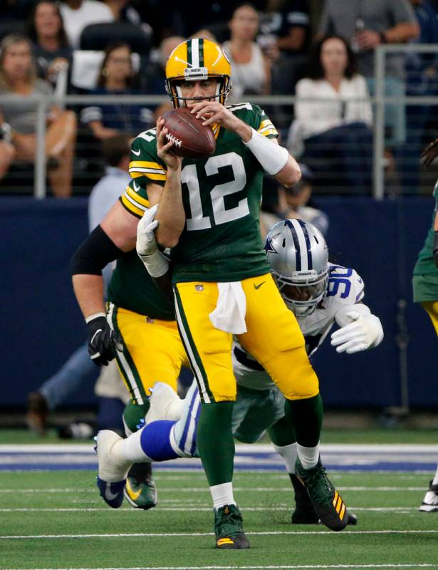 Green Bay Packers' Aaron Rodgers (12) throws an incomplete pass under pressure from Dallas Cowb ...