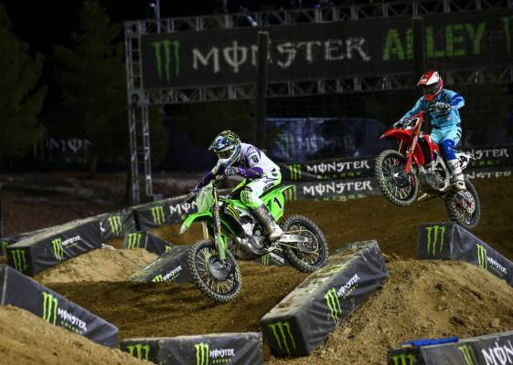 Eli Tomac (1) rides past Vince Friese (64) during the first round of the Monster Energy Cup Sup ...