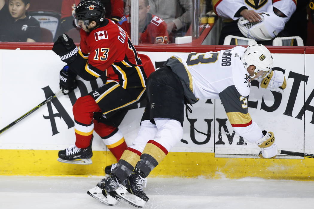 Vegas Golden Knights' Brayden McNabb, right, checks Callgary Flames' Johnny Gaudreau during fir ...