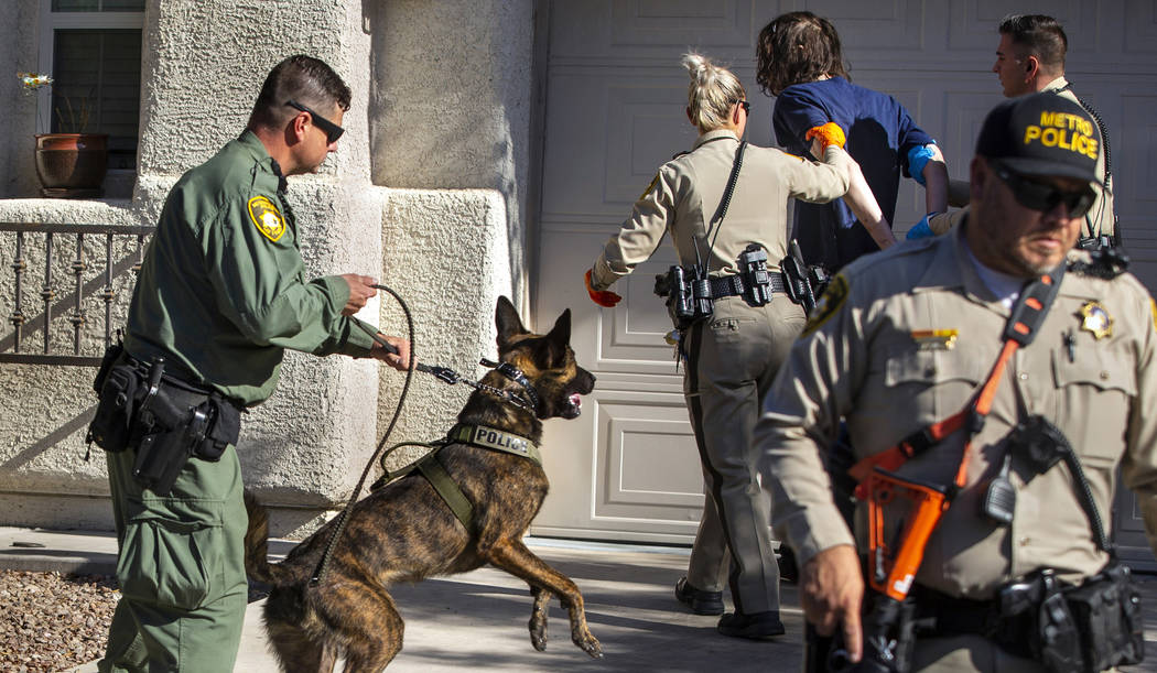 Metropolitan Police Department K-9 officer Jason Dukes secures his dog, Argos, while fellow off ...