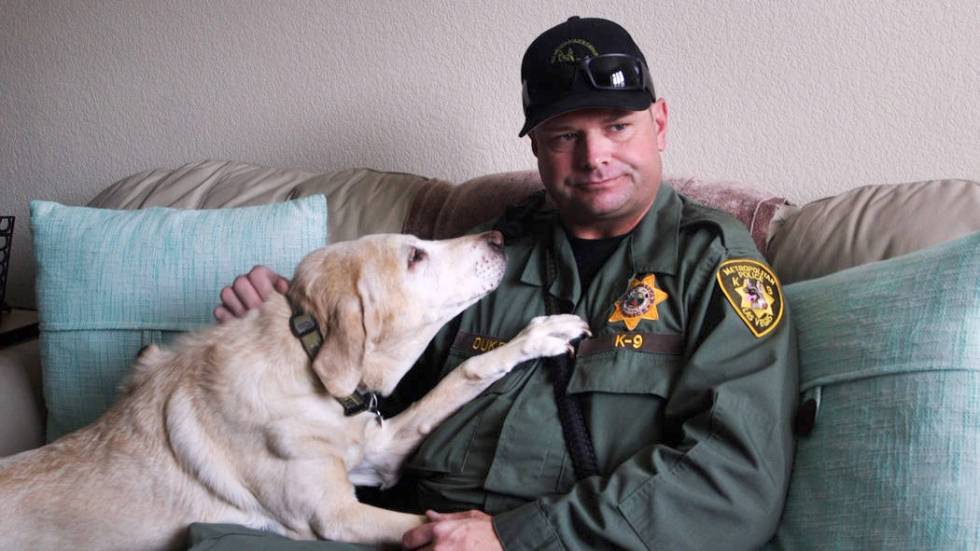 K-9 officer Jason Dukes cuddles with his retired narcotics detection dog, Maddie, at his home o ...